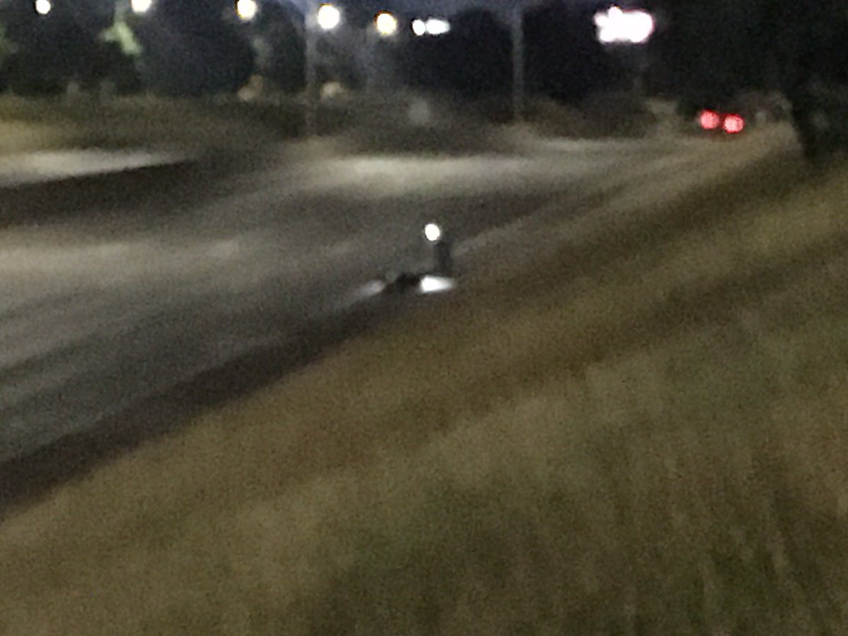 Fatal car-motorcycle accident closes I-75 S at 7 Mile. Michigan State Police investigators on freeway using  flashlights. Skid marks indicate impact was north of 7 mile with car under first turn-around south, and motorcycle further south.