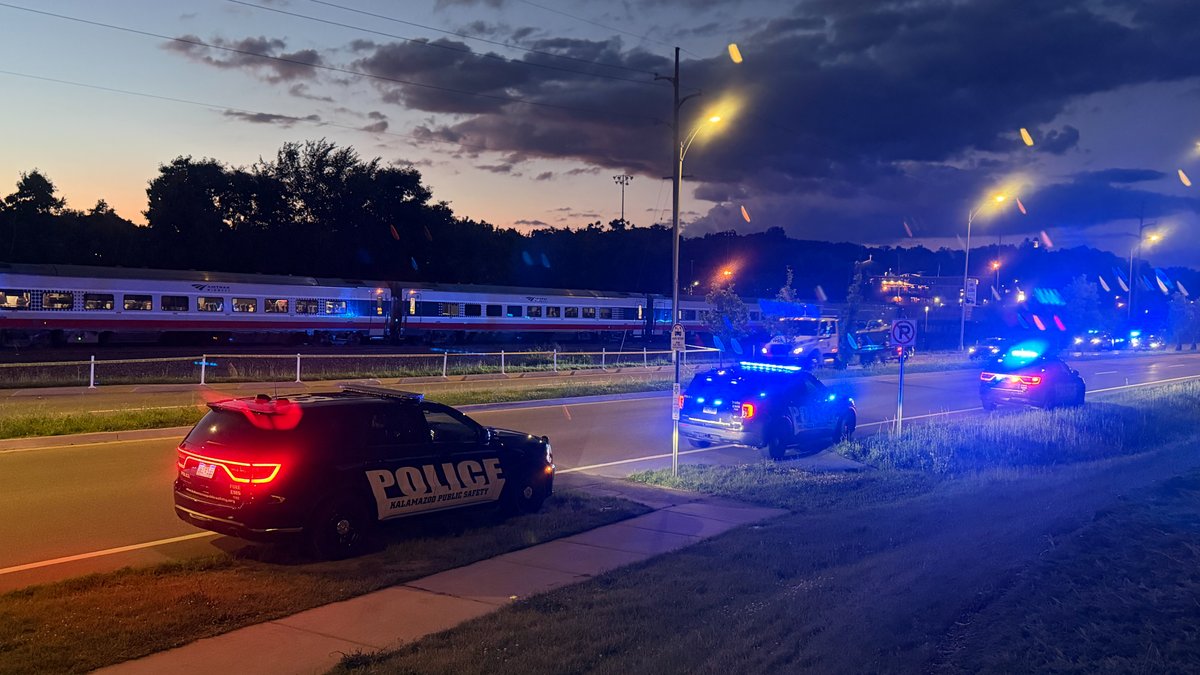 Police have gathered near train tracks in Kalamazoo, where an Amtrak train is stopped on the tracks: